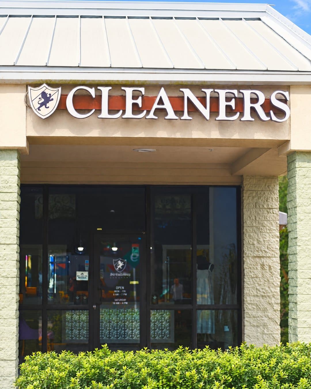 The Sir Galloway store in Palmetto Bay: its crest sign under a metal roof, above a glass front and a low hedge